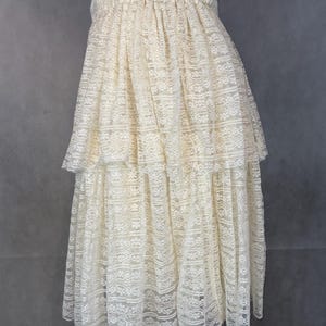 May include: A white lace skirt with multiple layers and a gathered elastic waistband.