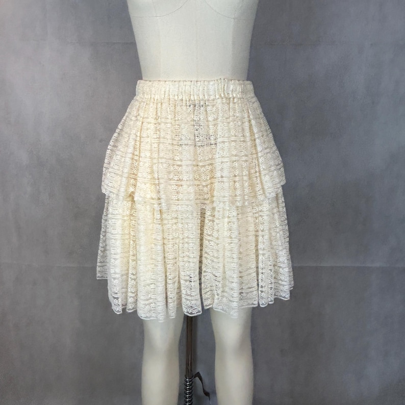 May include: A white tiered lace skirt with a ruffled hem.