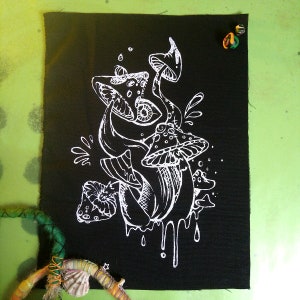 Puede incluir: Dibujo de línea blanca de hongos en un parche de tela negro. Los hongos están estilizados y tienen un aspecto psicodélico. El parche es perfecto para agregar un toque único a la ropa, bolsos u otros accesorios.