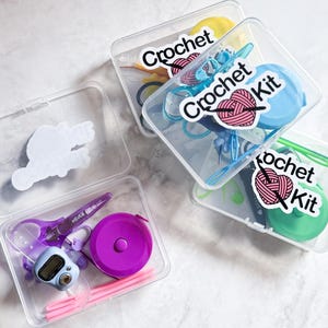 May include: Four clear plastic containers with colorful crochet supplies and labels that say "Crochet Kit".