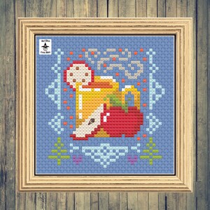 May include: Cross stitch pattern of a mug of apple cider with a red apple and a cinnamon stick. The pattern is on a blue background with a white border. The text "Bad Witch Cross Stitch" is in the top left corner.
