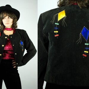 May include: A black suede jacket with colourful kite embroidery on the back. The kites are yellow, blue, and red with gold thread accents.