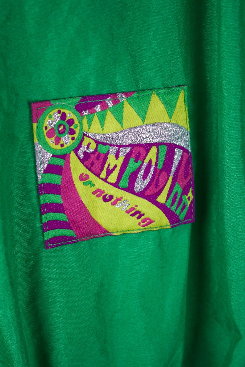 May include: Green jacket with a colourful patch that says "Playful or nothing" in a retro font with silver glitter accents.