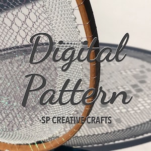 Puede incluir: Primer plano de un patrón de encaje de crochet blanco en un aro de bordado de madera. El texto "Digital Pattern -SP CREATIVE CRAFTS" es visible debajo del aro.