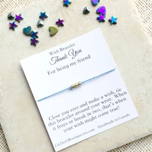May include: A light blue wish bracelet with silver beads and a card that reads "Wish Bracelet Thank You For being my friend Close you eyes and make a wish, tie this bracelet around your wrist. When it frays or break in two, that's when your wish might come true! LilyDailyBoutique.etsy.com Handmade in Canada"