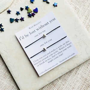 Op de afbeelding: Twee zwarte armbandjes van koord met zilveren kralen en de tekst "Wish Bracelet I'd be lost without you one for me one for you Close you eyes and make a wish, tie this bracelet around your wrist. When it frays or break in two, that's when your wish might come true! LilyDailyBoutique.etsy.com Handmade in Canada"