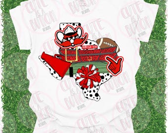 May include: White t-shirt featuring a Texas-shaped graphic with a red and black cowboy, football, pom-pom, and the words "WRECK 'EM". The design includes a football field and a red hand pointing to the right. The shirt is decorated with black and white polka dots.