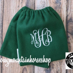May include: Green fleece boot cuffs with a white monogram "MHB" embroidered on the front. The cuffs are made in Montana, USA.  @snowymountainhorseshop