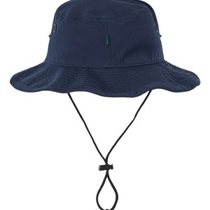 Pode incluir: Um chap&eacute;u de balde azul marinho com um cord&atilde;o de ajuste preto e um bot&atilde;o. O chap&eacute;u tem uma aba larga e uma coroa plana.