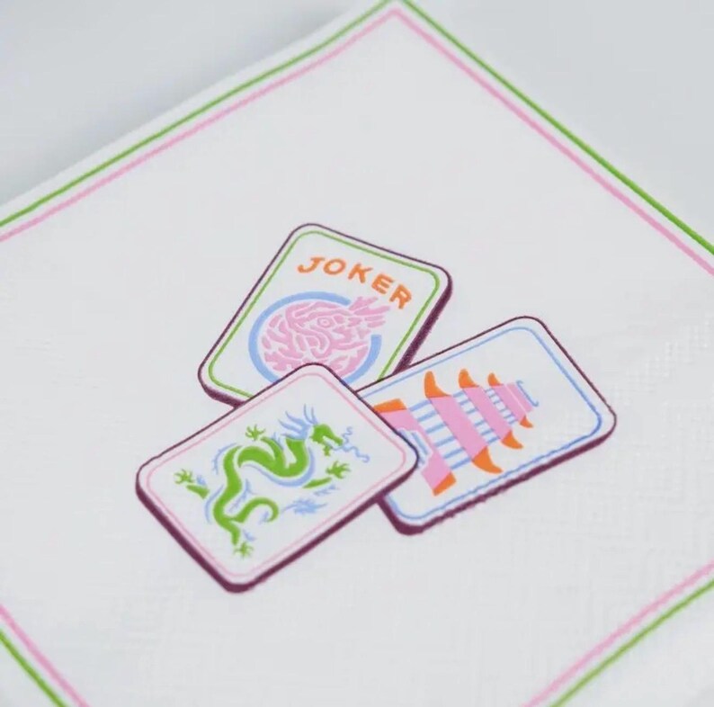 K&ouml;nnte beinhalten: Wei&szlig;es Taschentuch mit rosa und gr&uuml;nem Rand, das drei Spielkarten zeigt. Die Karten zeigen einen Drachen, eine Pagode und ein Gehirn mit dem Wort "JOKER". Das Design ist in Rosa-, Gr&uuml;n- und Blaut&ouml;nen gehalten.