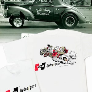 Könnte beinhalten: Ein weißes T-Shirt mit einem rot-schwarzen Hurst Hydro-Gate Logo. Die Rückseite des Shirts zeigt eine Comic-Illustration eines Dragsters mit einem Fahrer in einem roten Rennanzug.