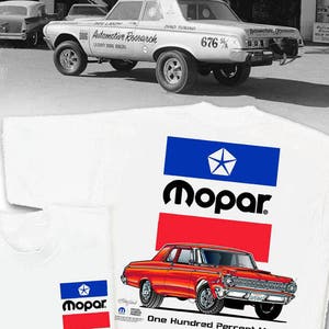 May include: A white t-shirt with a red, white, and blue Mopar logo and a red Dodge Dart illustration. The text "One Hundred Percent Mopar" is printed below the car.