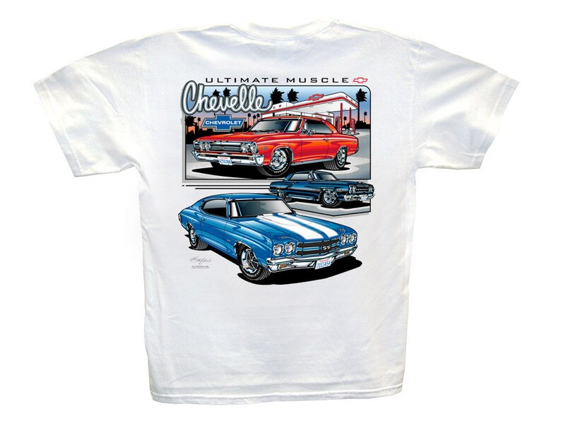 Op de afbeelding: Wit T-shirt met een afbeelding van drie klassieke Chevelle muscle cars. De auto's zijn rood, blauw en blauw met een witte streep. De tekst "ULTIMATE MUSCLE" en "Chevelle" staat op het shirt gedrukt.