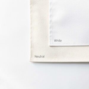 May include: Two fabric swatches, one labelled "White" and the other labelled "Neutral". The "White" swatch is a bright white, while the "Neutral" swatch is a slightly off-white colour.