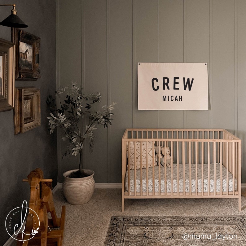 Nursery name sign canvas flag with personalized first and middle name in black block letters on cream canvas