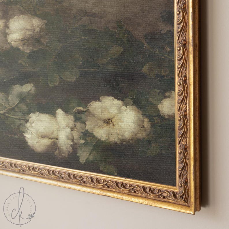 May include: A framed painting of white flowers with green leaves on a dark background. The frame is gold with an ornate design.