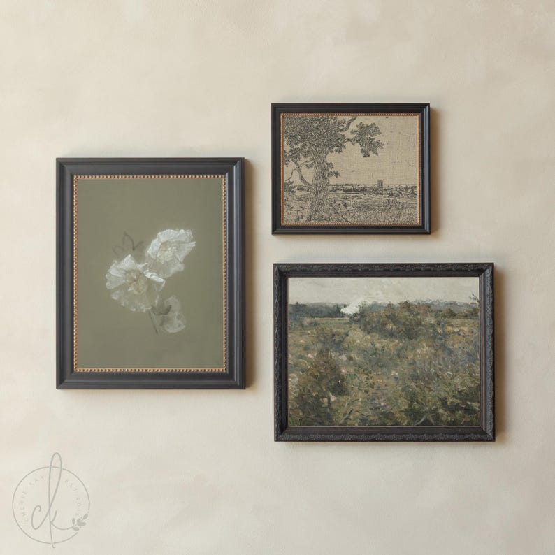 May include: Three framed wall art pieces featuring a vertical portrait with white flowers on a sage green background, a horizontal landscape sketch of a tree, and a horizontal landscape painting of a field, all enclosed in dark brown frames.
