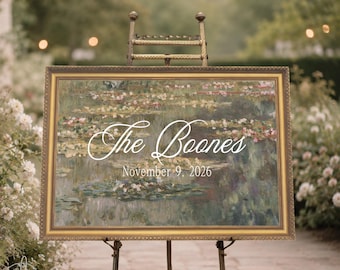 Puede incluir: Un letrero rectangular en un marco dorado con una impresión de pintura de nenúfares. El texto "The Boones" está escrito en cursiva blanca sobre la fecha "November 9, 2026" en una fuente blanca sencilla. El letrero se exhibe en un caballete metálico.