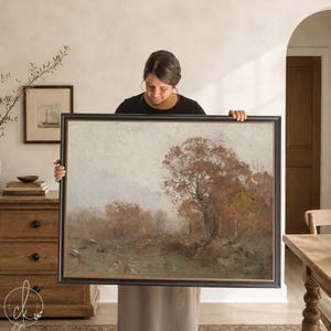 May include: A large rectangular landscape painting in a black frame featuring a muted autumn scene with brown and orange trees, a grassy field, and a soft, overcast sky. The artwork displays a textured, painterly style with earthy tones.