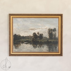 May include: A framed landscape painting with a gold ornate frame. The artwork depicts a serene river scene with trees and a cloudy sky. The painting's colors are muted, with shades of green, gray, and brown.