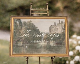 May include: A rectangular sign in a gold frame featuring a landscape painting of a stone castle by a lake with swans and a boat. The text reads The Ashcrofts and November 7, 2026 in white script and serif fonts. The sign rests on a metal easel.