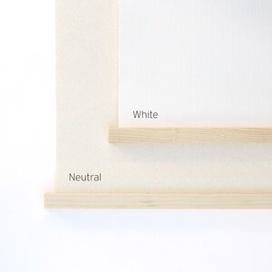 May include: Two wooden frames, one labeled "White" and the other labeled "Neutral". The frames are made of natural wood and have a simple, minimalist design.