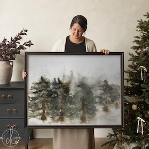 Framed Christmas wall art with watercolor pine trees in a winter forest scene.