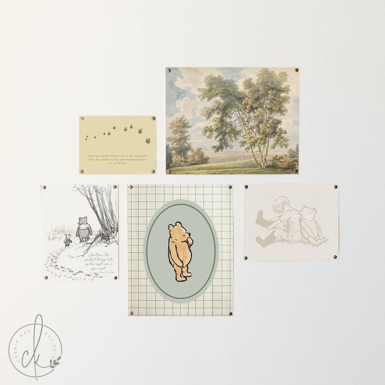 May include: A collection of framed art pieces featuring Winnie the Pooh and nature scenes. The art includes illustrations of Pooh Bear, quotes, and a landscape painting. The frames are mounted on a white wall.