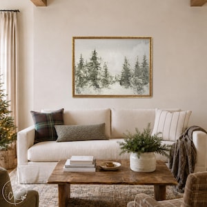 May include: A rectangular landscape painting in a gold frame depicting a forest of evergreen trees in a snowy, muted setting. The artwork features soft gray and green tones, capturing a winter scene with pine trees and a hazy, overcast sky.
