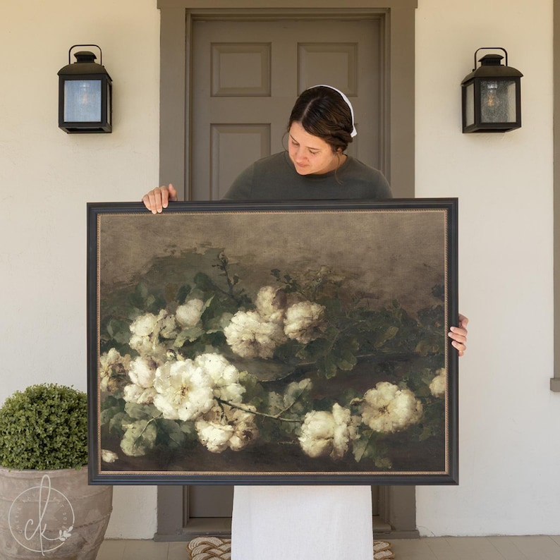 May include: A framed painting of a bouquet of white roses with green leaves on a dark brown background.