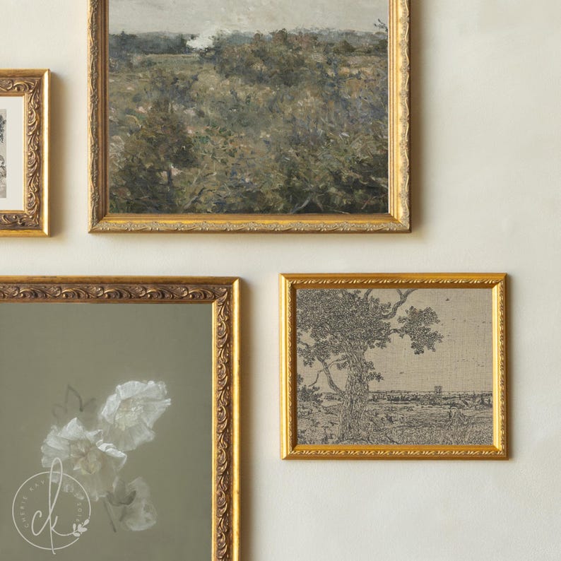 May include: A gallery wall arrangement featuring three framed artworks. One large landscape painting in a gold ornate frame, a smaller black and white line drawing of a tree in a gold frame, and a vertical print of white flowers in a gold frame.