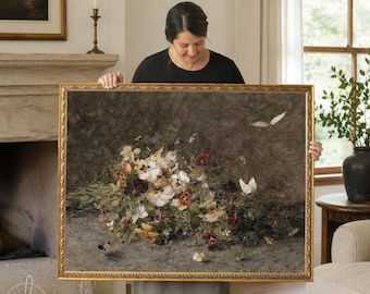 May include: A rectangular framed wall art piece featuring a dark, textured background with a cluster of white, yellow, and deep red pansies. Two white butterflies are depicted in flight near the flowers, all enclosed in a gold ornate frame.