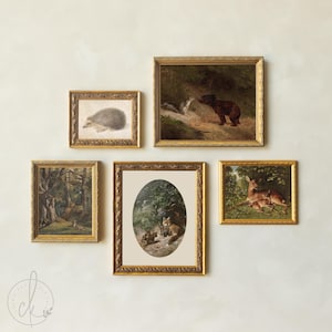 May include: A gallery wall set of five framed prints featuring woodland animals. The collection includes a hedgehog, a bear and squirrel, a forest landscape, a fox with kits in an oval frame, and a deer with a fawn, all in ornate gold frames.