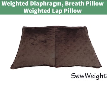 May include: A brown, weighted lap pillow with a textured surface. The pillow is trapezoid-shaped and designed for breath support. The text at the top reads "Weighted Diaphragm, Breath Pillow, Weighted Lap Pillow."