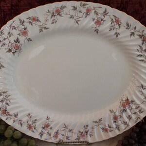 May include: White oval serving platter with a scalloped edge and a floral design in shades of pink and brown.