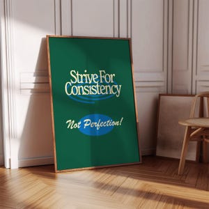 Puede incluir: Un póster enmarcado con fondo verde y el texto "Strive For Consistency" en letras doradas, con un óvalo azul y las palabras "Not Perfection!" en blanco. El marco es de color marrón claro.