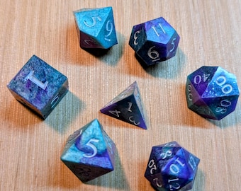 Conjunto de 7 dados em tons de verde-azulado e roxo