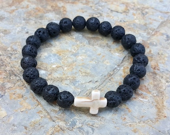 May include: Black lava rock beaded bracelet with a white cross charm.