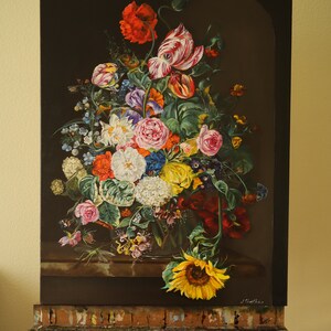 May include: A vibrant floral still life painting featuring a variety of flowers, including red poppies, tulips, roses, and a sunflower. The artwork is displayed on an easel, showcasing the colorful arrangement against a dark background.