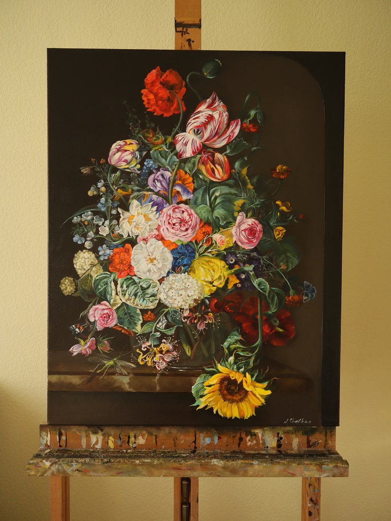 May include: A vibrant floral still life painting featuring a variety of flowers, including red poppies, tulips, roses, and a sunflower. The artwork is displayed on an easel, showcasing the colorful arrangement against a dark background.