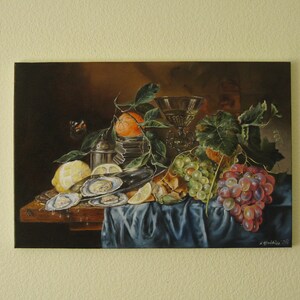 May include: A still life oil painting on canvas depicting a dark scene with oysters on a silver platter, a lemon, an orange with green leaves, a glass goblet, and clusters of green and red grapes resting on a blue draped cloth surface.
