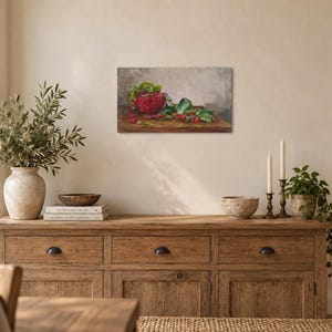 May include: A rectangular canvas wall art print featuring a still life oil painting of a red bowl filled with fresh raspberries, accompanied by loose berries and green leaves resting on a dark wooden surface against a neutral gray background.