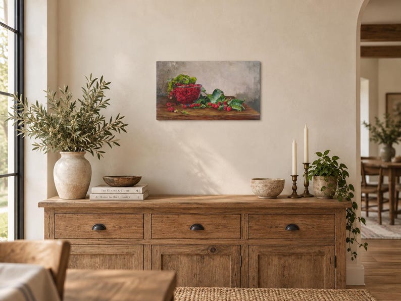 May include: A rectangular canvas wall art print featuring a still life oil painting of a red bowl filled with fresh raspberries, accompanied by loose berries and green leaves resting on a dark wooden surface against a neutral gray background.
