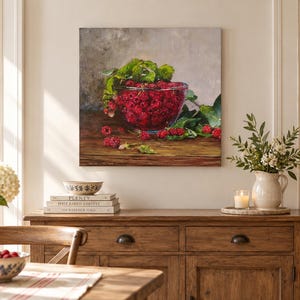 May include: A square wall art print featuring an oil painting of a glass bowl filled with bright red raspberries and green leaves. The bowl sits on a dark wooden surface against a neutral, textured background, capturing a still life composition.