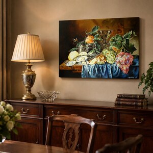 May include: A rectangular oil painting depicting a still life arrangement of oysters, a lemon, green and red grapes, and a glass goblet on a wooden table draped with a blue cloth. The artwork features warm lighting and rich, dark, earthy tones.