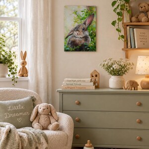 May include: A rectangular wall art print featuring a realistic painting of a brown rabbit nestled among green foliage. The artwork displays soft lighting and natural tones, capturing the rabbit's fur texture and alert expression in a detailed style.