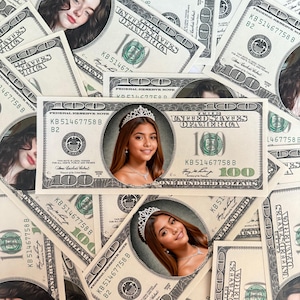 May include: A collection of United States one hundred dollar bills. Several bills feature a portrait of a young person wearing a tiara. The bills are green and white with the text "ONE HUNDRED DOLLARS".