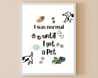 May include: White framed print with the text "I was normal until I got a pet." The print features cartoon illustrations of a dog, paw prints, a spilled plant, and other pet-related imagery. The text is in black.