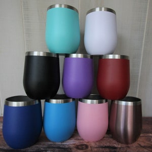 May include: Set of nine stainless steel wine tumblers in various colors, including teal, white, black, purple, red, blue, light blue, pink, and rose gold.