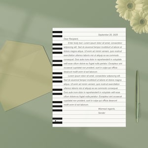May include: A letter with text, an envelope, a pen, and flowers on a green surface. The letter has a piano key design on the left side. The text includes a date and a salutation.